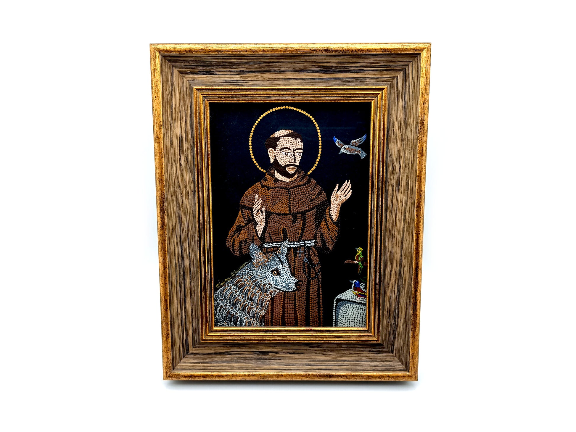 A framed religious icon depicting Saint Francis of Assisi with a brown robe, gold halo, and a silver wolf on a dark background, enclosed in a rustic brown wooden frame with gold trim.