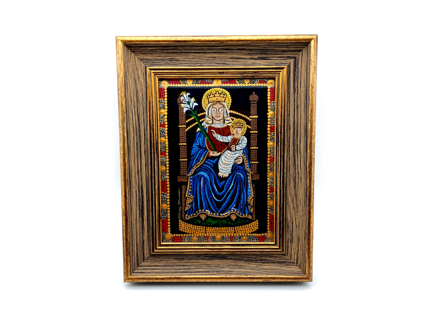 A framed religious artwork depicting the Madonna and Child, with a dark blue robe, gold crown, and ornate multicolor border, set within a wide brown wooden frame on a white background.