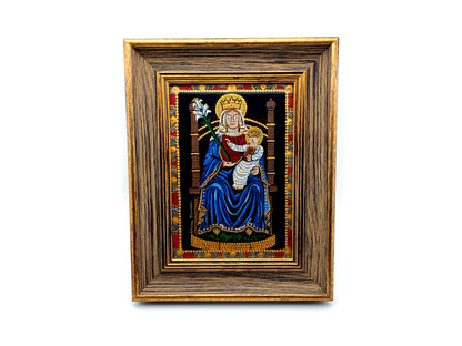 A framed religious artwork depicting the Madonna and Child, with a dark blue robe, gold crown, and ornate multicolor border, set within a wide brown wooden frame on a white background.