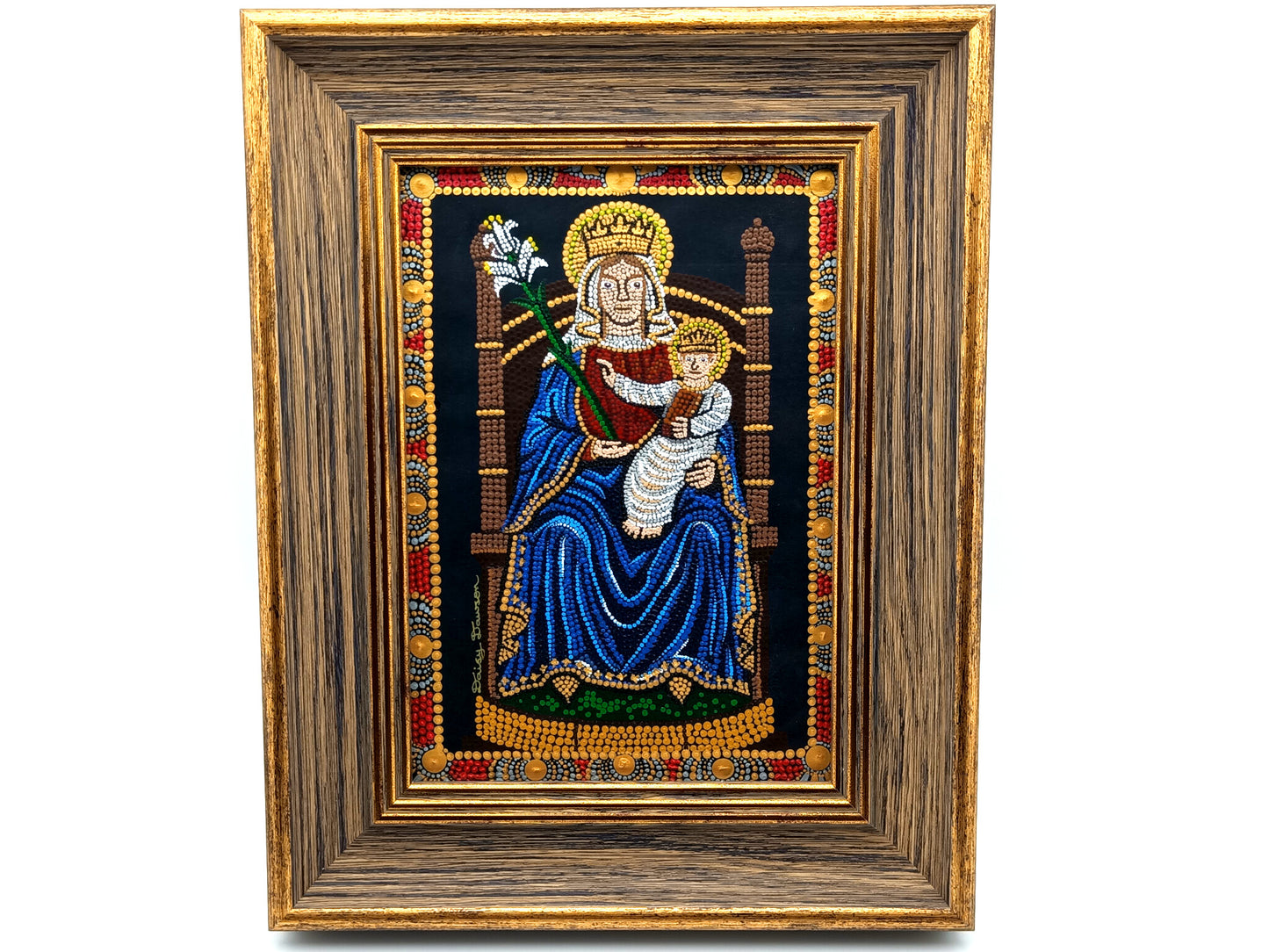 A framed religious artwork depicting the Madonna and Child, with a dark blue robe, gold crown, and ornate multicolor border, set within a wide brown wooden frame on a white background.