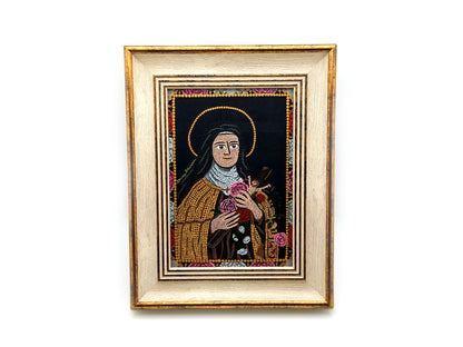 A framed religious mosaic icon portrait of Saint Therese of Lisieux, featuring a cream and gold-toned frame and a detailed multicolor mandala design on a white background.