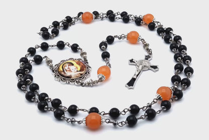 Our Lady of Laus unique rosary beads with black onyx gemstone and tangerine glass beads, black enamel crucifix and silver picture centre medal.