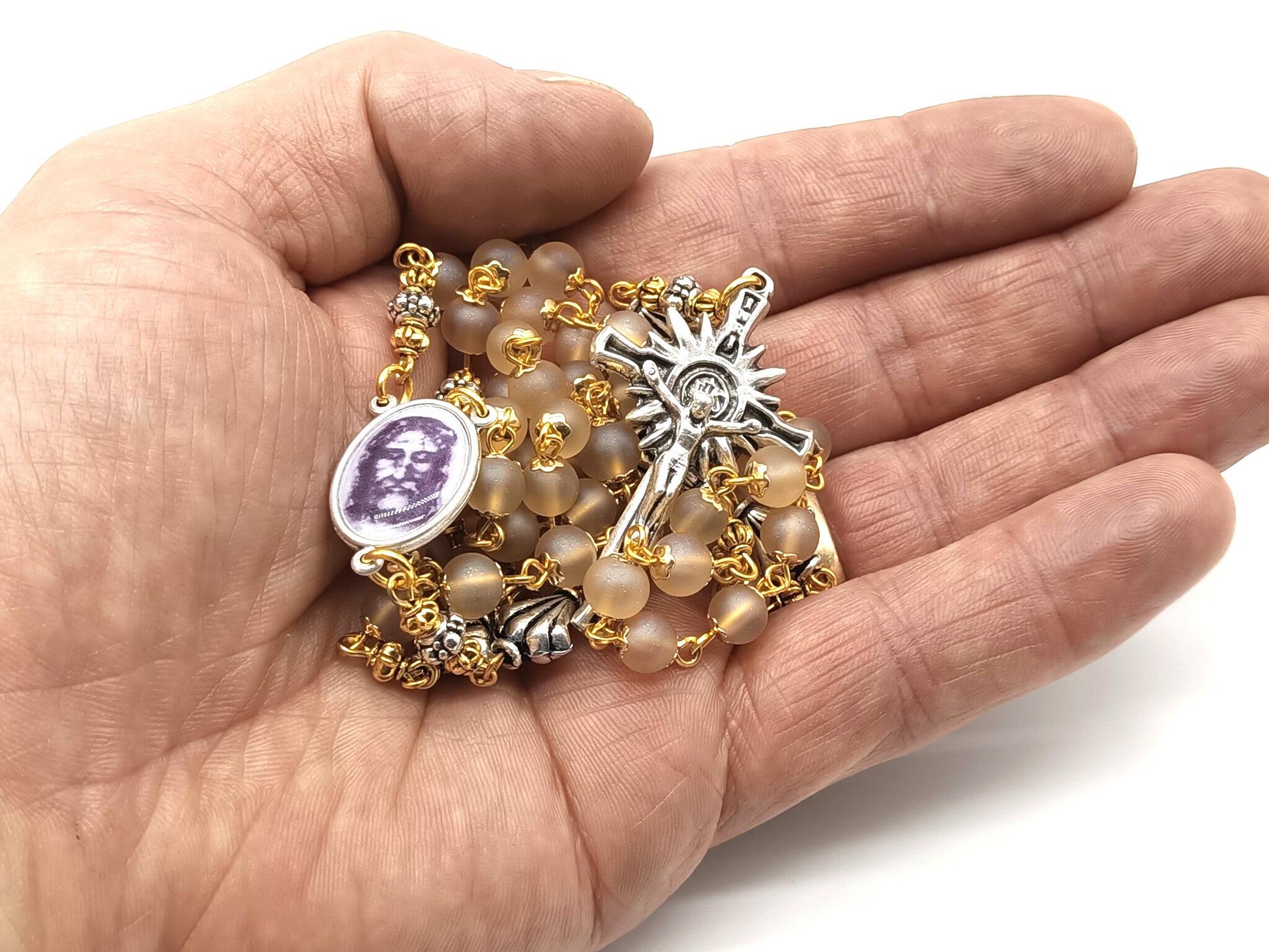 The Holy Face of Jesus rosary beads with pale gold glass beads and silver crucifix and centre medal.