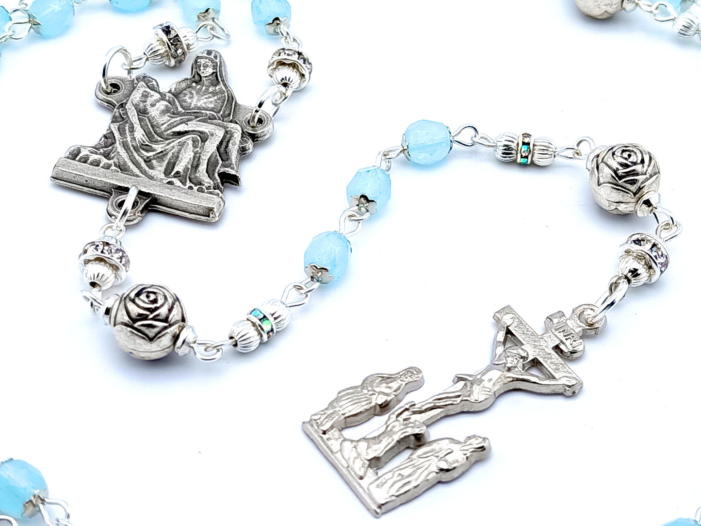 La Pieta unique rosary beads with pale blue glass and silver roses beads, silver two Marys crucifix and La Pieta centre medal.