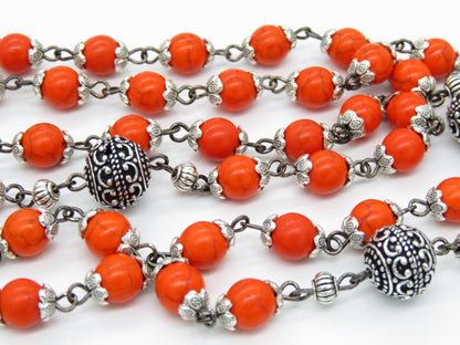 Heirloom Virgin Mary unique rosary beads with orange gemstone beads, silver bead caps, pater beads, picture centre medal and silver and black enamel crucifix.