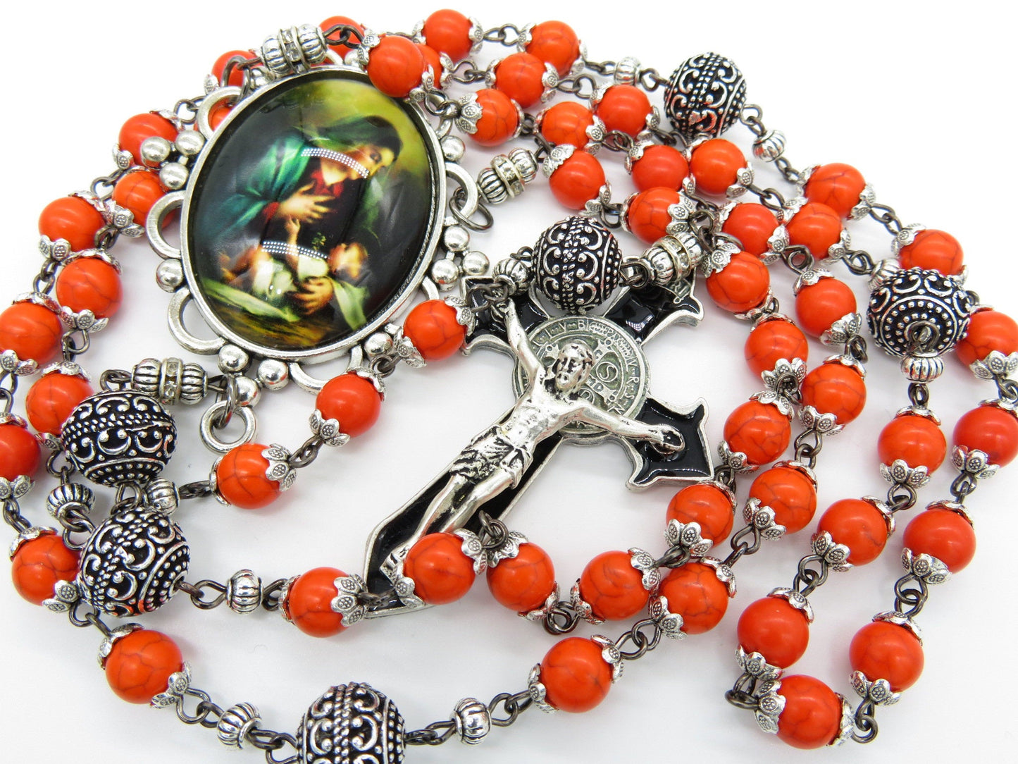 Heirloom Virgin Mary unique rosary beads with orange gemstone beads, silver bead caps, pater beads, picture centre medal and silver and black enamel crucifix.