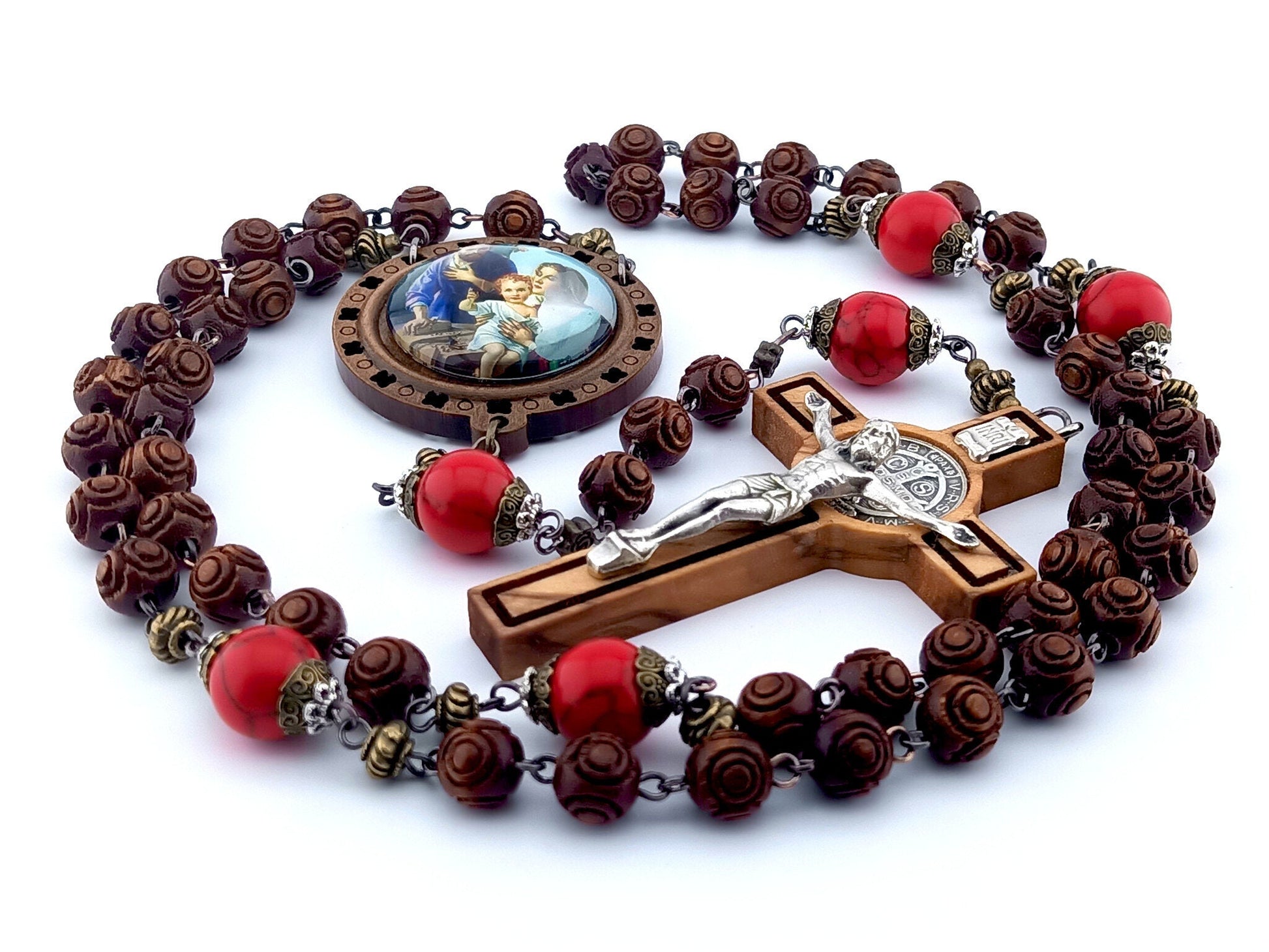 The Nativity unique rosary beads with carved wooden beads, Saint Benedict crucifix, picture centre medal and large red gemstone pater beads.