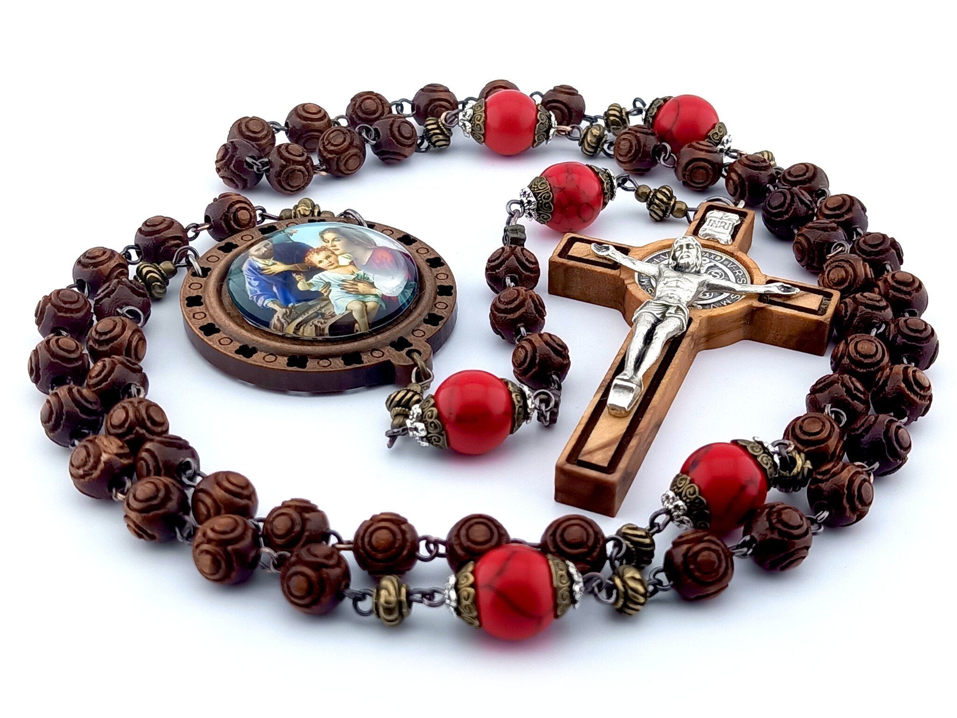 The Nativity unique rosary beads with carved wooden beads, Saint Benedict crucifix, picture centre medal and large red gemstone pater beads.