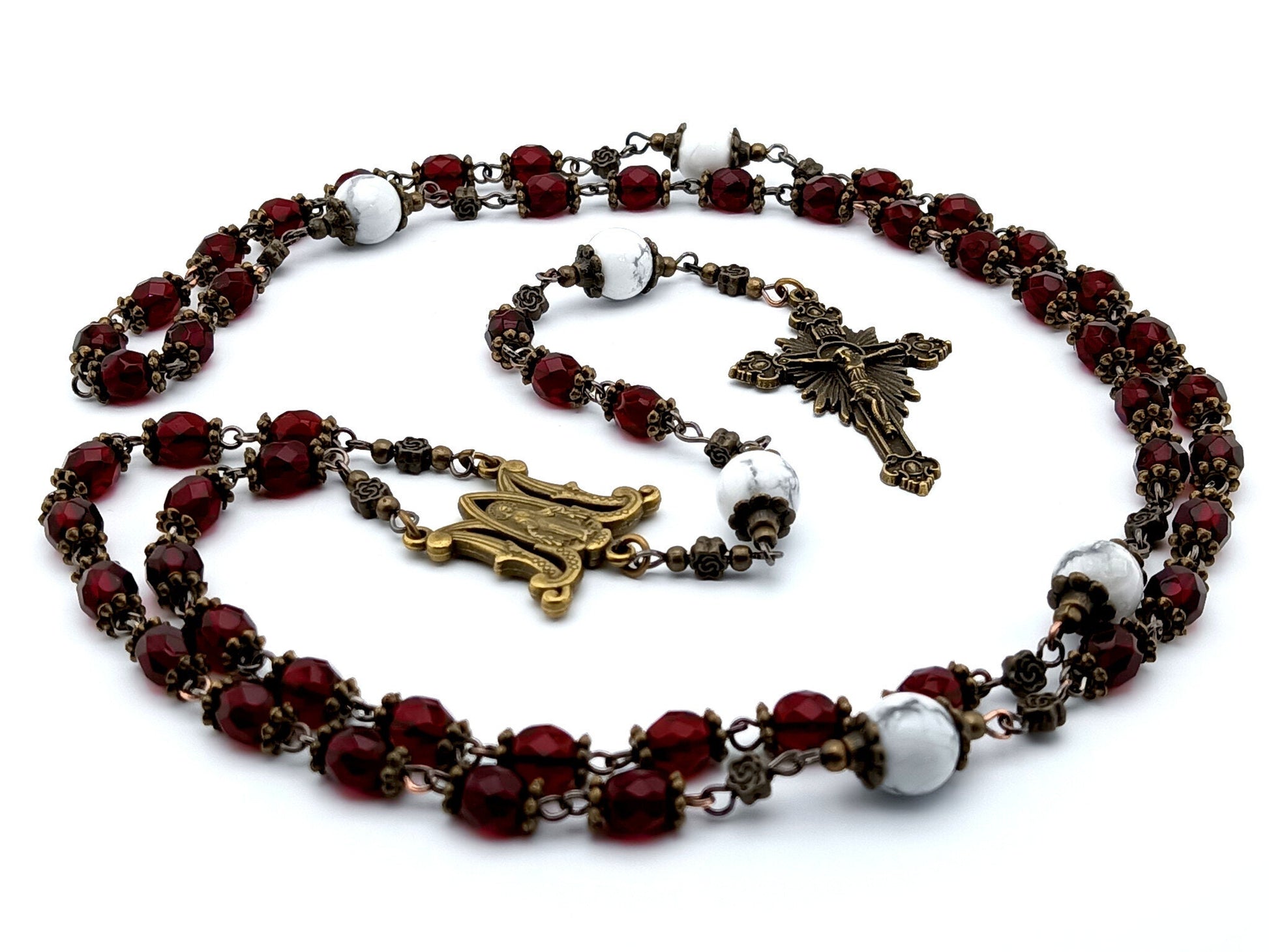 Miraculous medal unique rosary beads with red faceted glass beads, bronze sunburst crucifix, metal centre medal and white howlite pater beads.