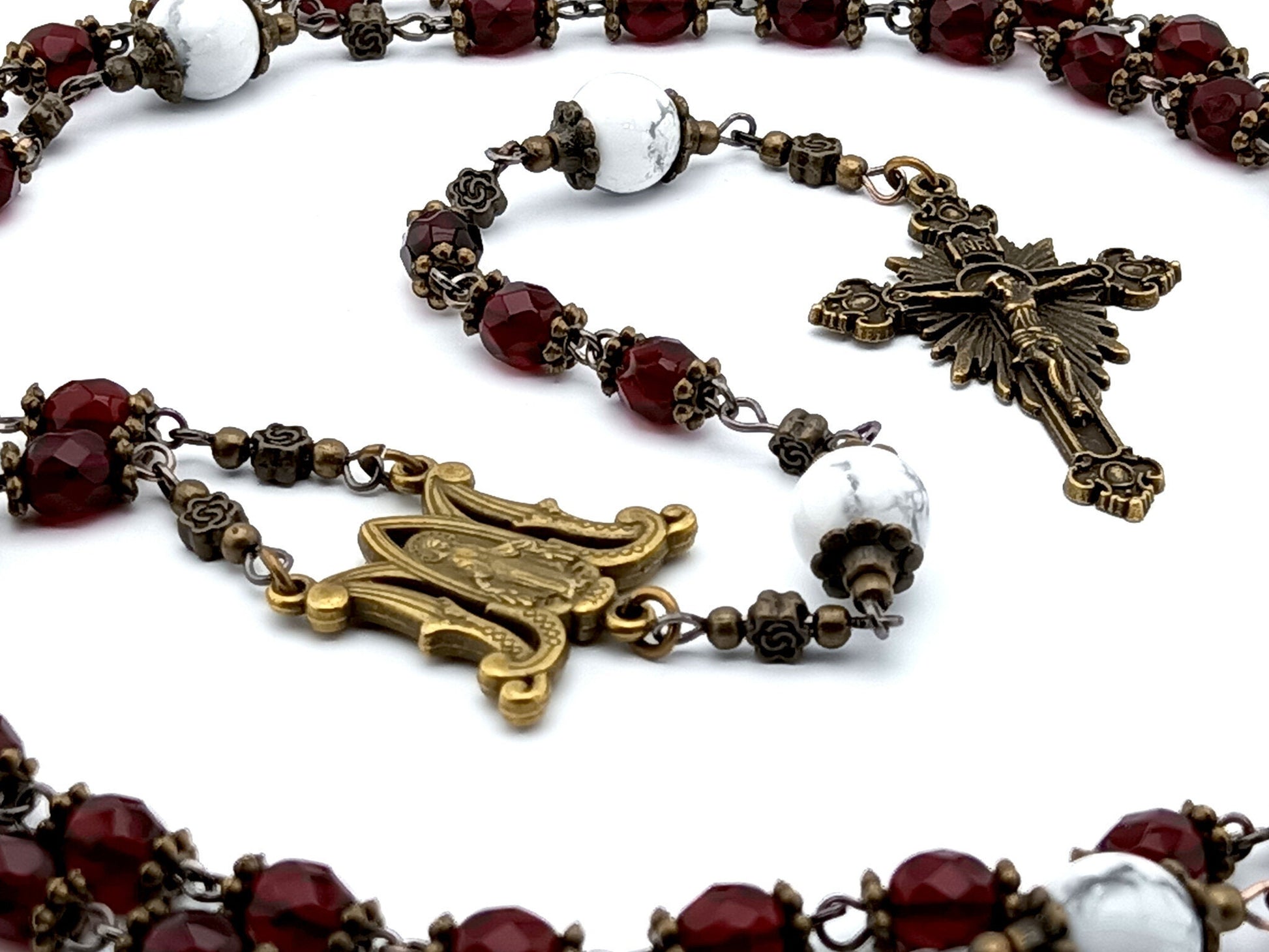 Miraculous medal unique rosary beads with red faceted glass beads, bronze sunburst crucifix, metal centre medal and white howlite pater beads.