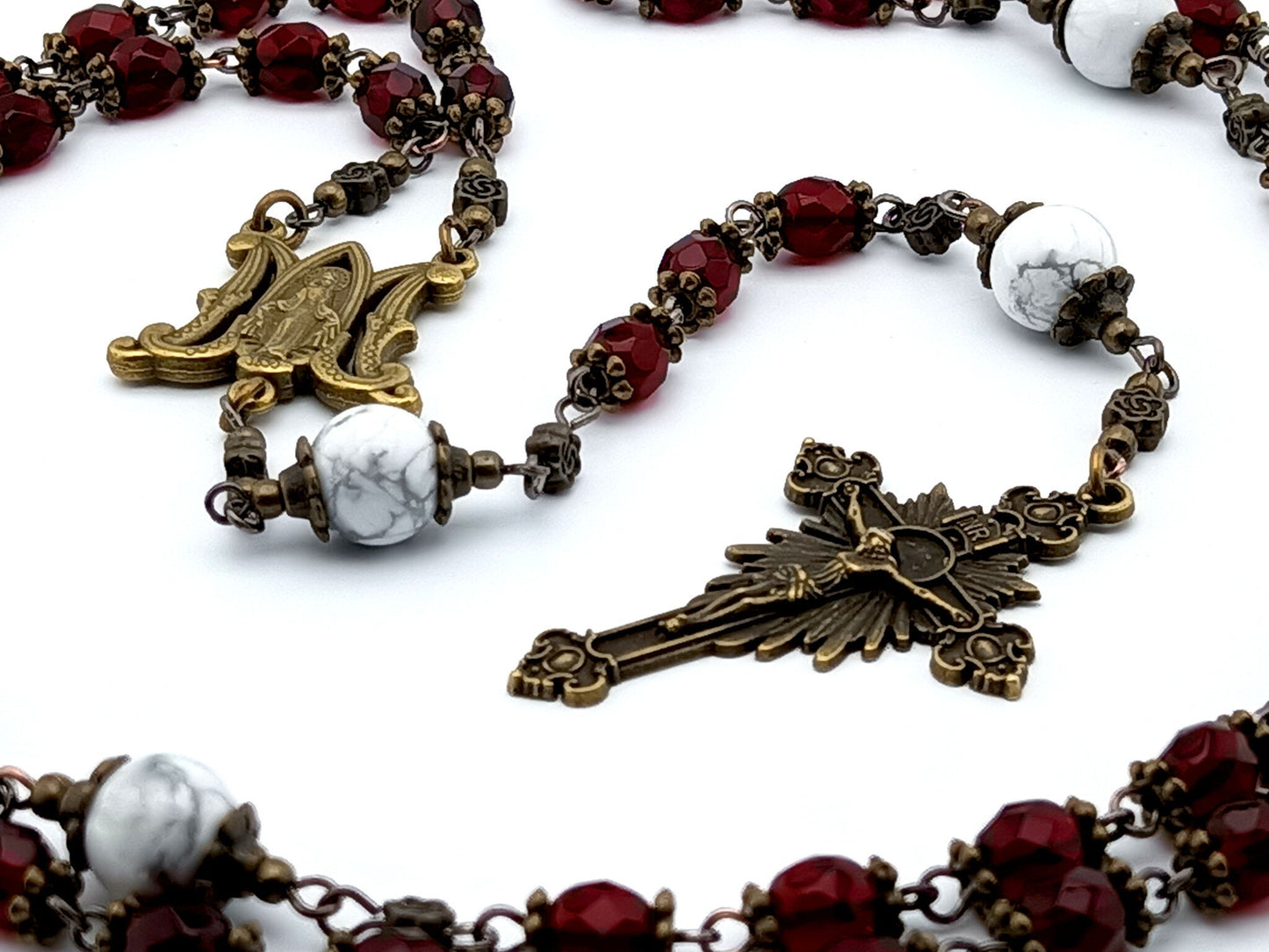 Miraculous medal unique rosary beads with red faceted glass beads, bronze sunburst crucifix, metal centre medal and white howlite pater beads.